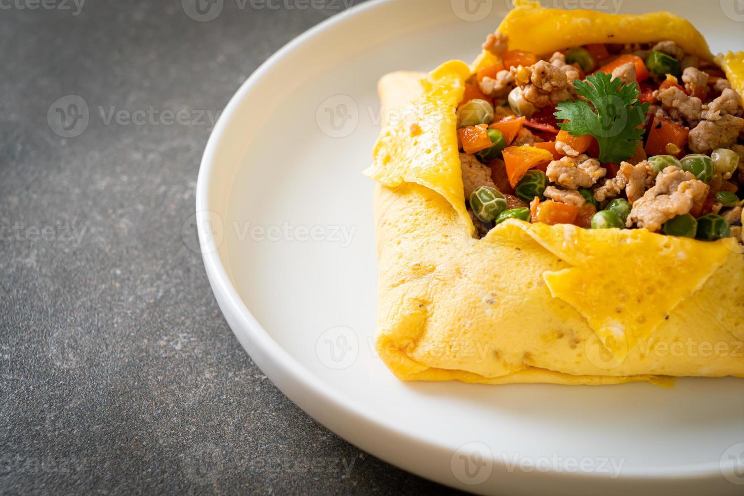 Eierwickel oder gefülltes Ei mit Hackfleisch, Karotten, Tomaten und grünen Erbsen foto