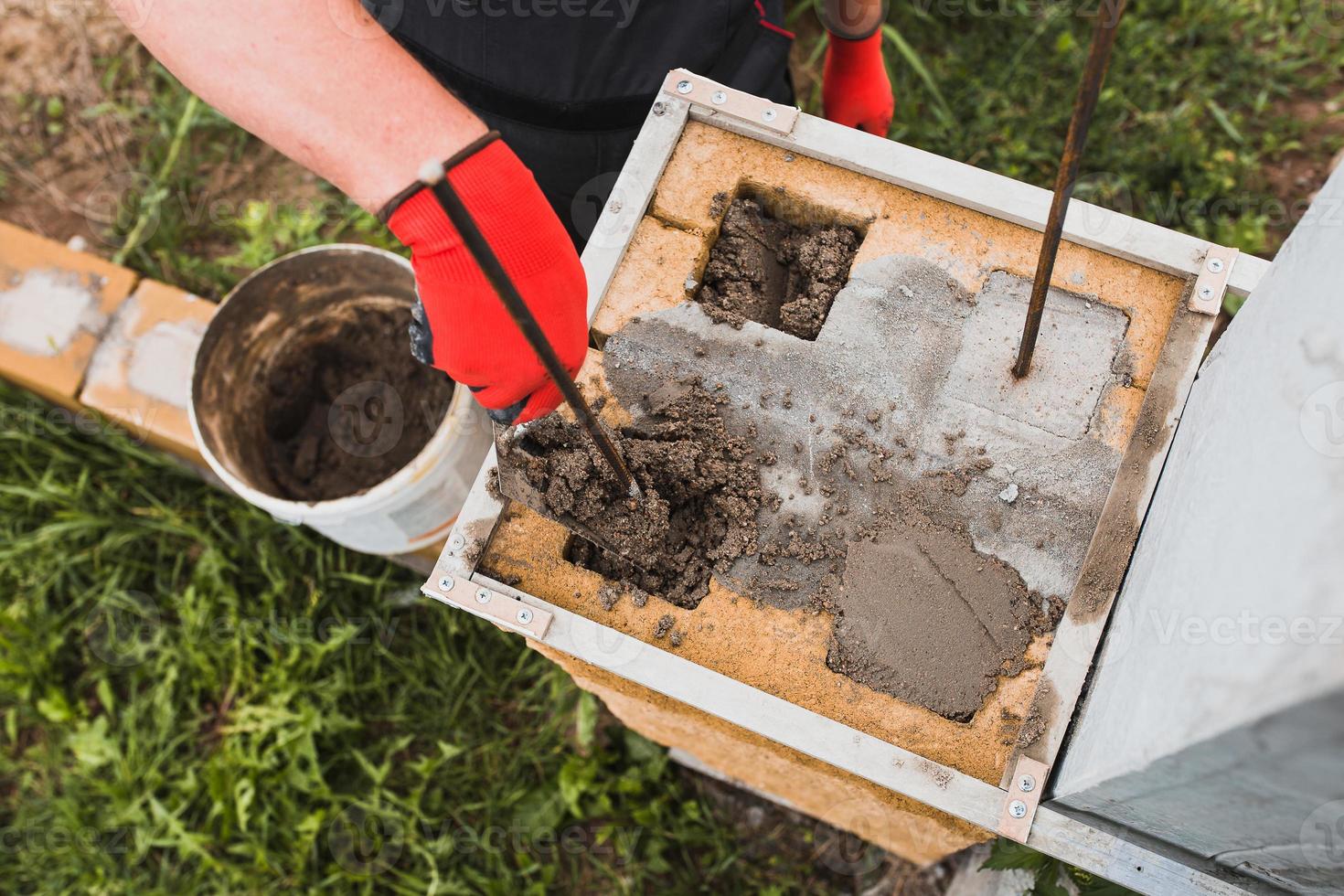 Bau einer Steinsäule aus Betonblöcken - Tragkonstruktion eines Ziegelzauns foto