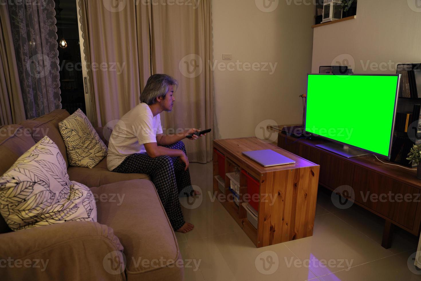 asiatischer Mann vor dem Fernseher foto