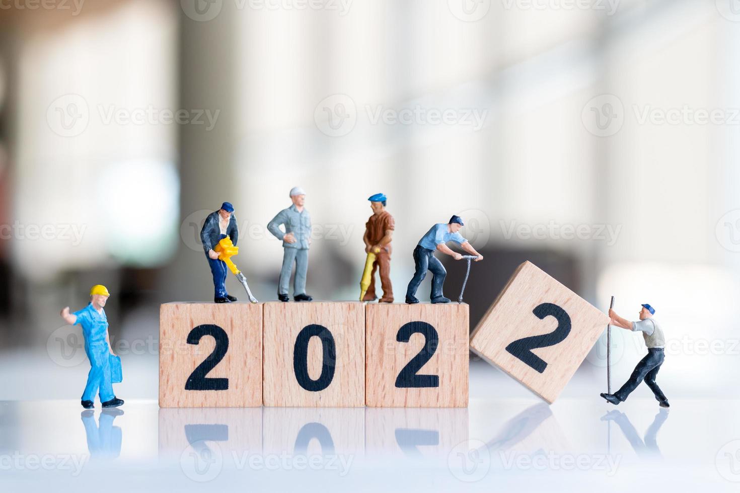 Miniatur-Leute-Arbeiter-Team erstellen Holzblock Nummer 2022 foto