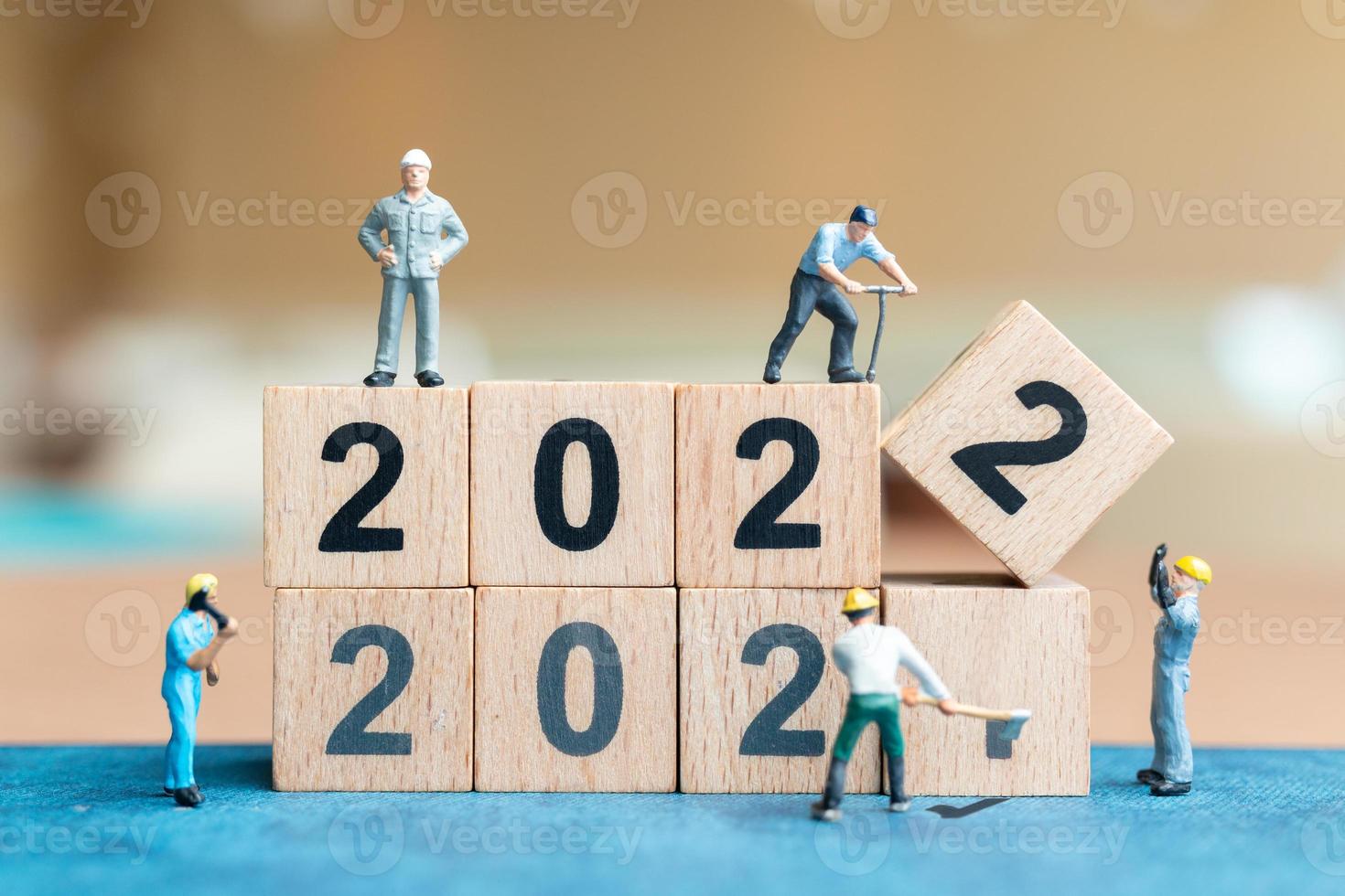 Miniatur-Leute-Arbeiter-Team erstellen Holzblock Nummer 2022 foto