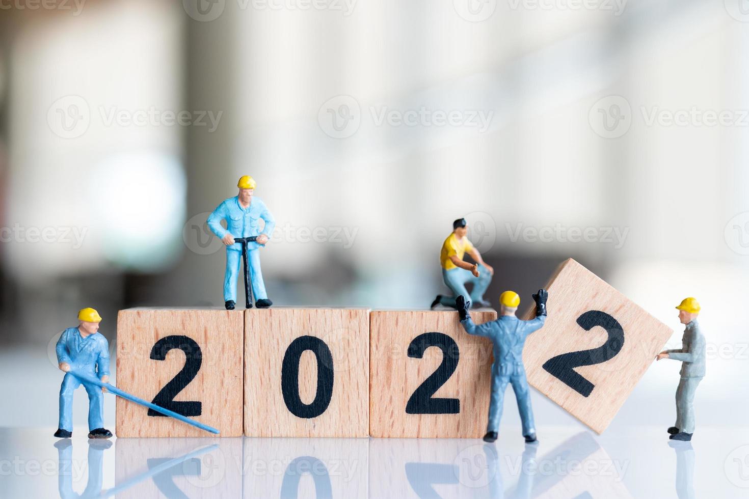 Miniatur-Leute-Arbeiter-Team erstellen Holzblock Nummer 2022 foto