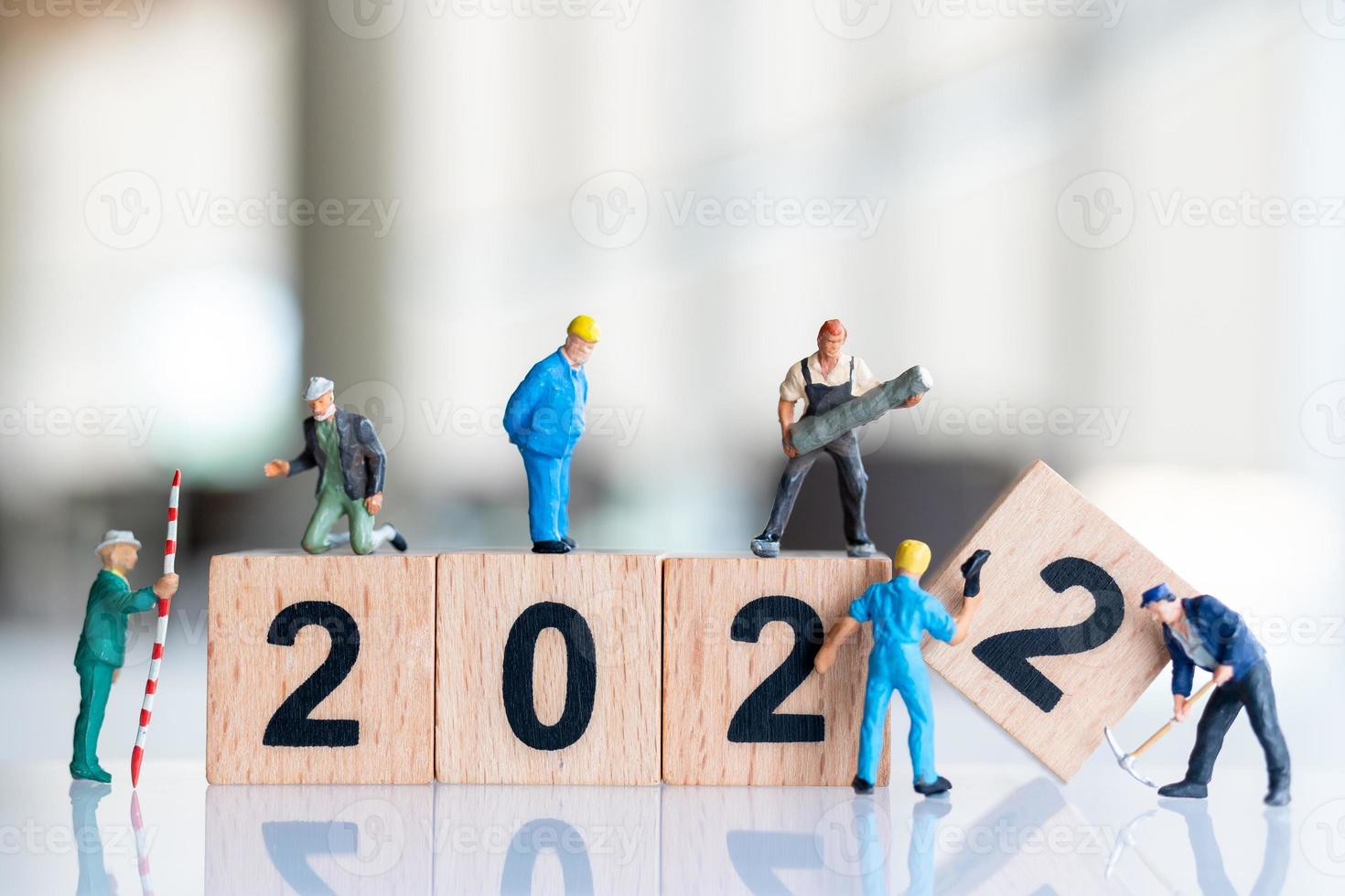 Miniatur-Leute-Arbeiter-Team erstellen Holzblock Nummer 2022 foto