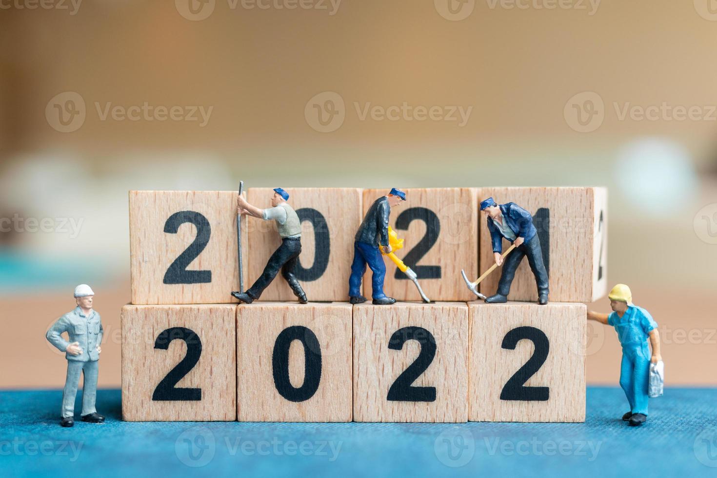 Miniatur-Leute-Arbeiter-Team erstellen Holzblock Nummer 2022 foto