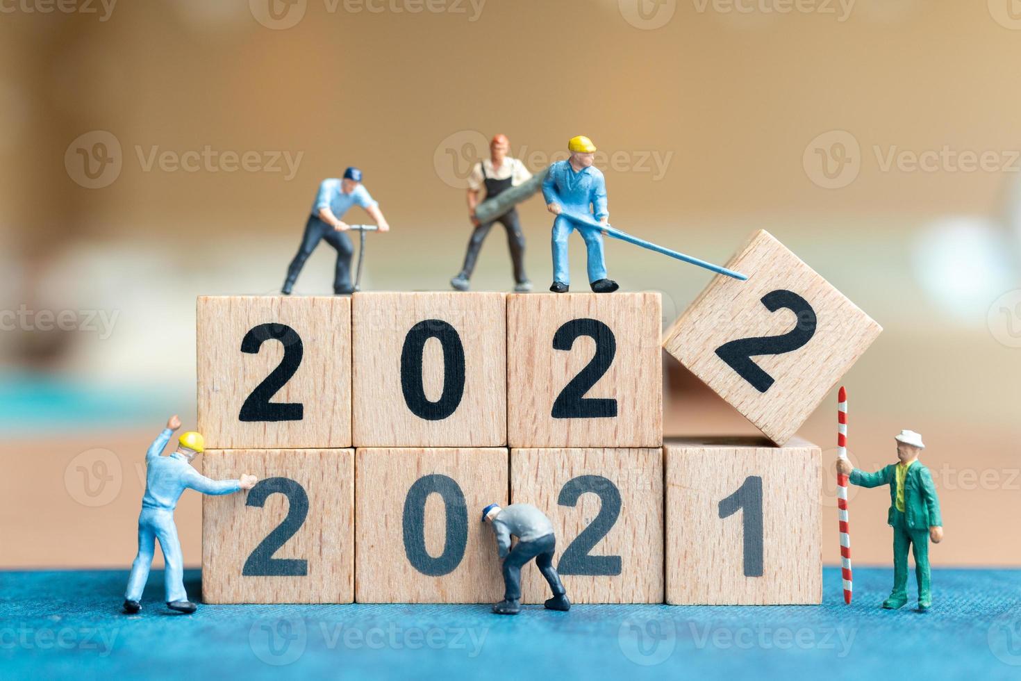 Miniatur-Leute-Arbeiter-Team erstellen Holzblock Nummer 2022 foto