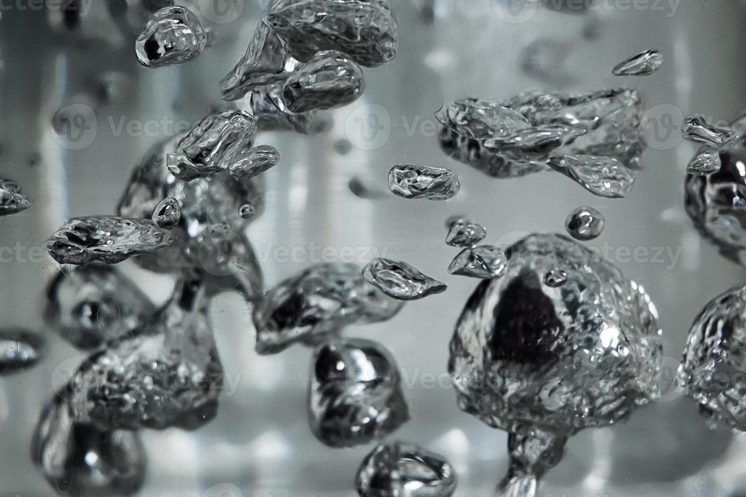 Tropfen und Blasen von Quecksilber in Wasser. gefährliches chemisches Element, die wissenschaftliche Erfahrung. foto