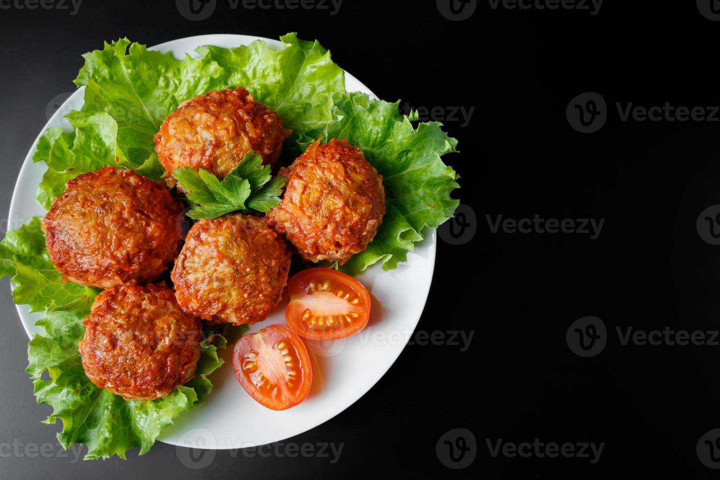 Fleischbällchen in Tomatensauce auf schwarzem Hintergrund. hausgemachte Proteinmahlzeit für eine gesunde Ernährung. foto