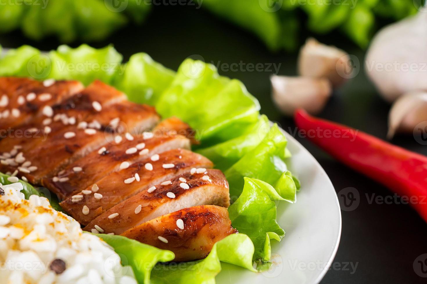 hausgemachtes Essen - Teriyaki-Hühnchen mit weißem Reis und Pfeffer auf schwarzem Hintergrund. foto