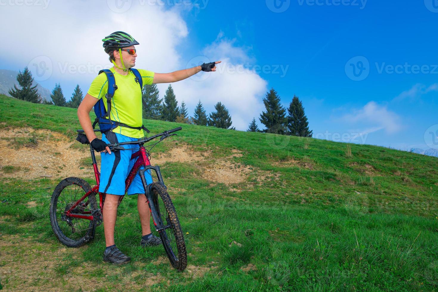 Ein junger Mann, der im Freien ein Mountainbike fährt, bedeckt den Weg foto