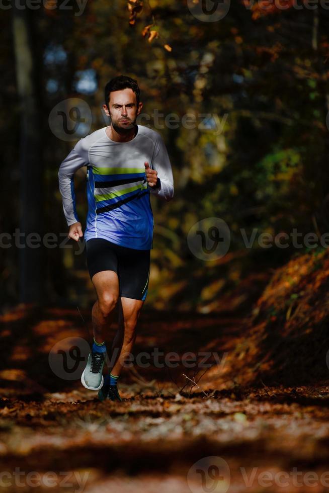 Laufsportler bei Marathonvorbereitungszügen im Herbstwald foto