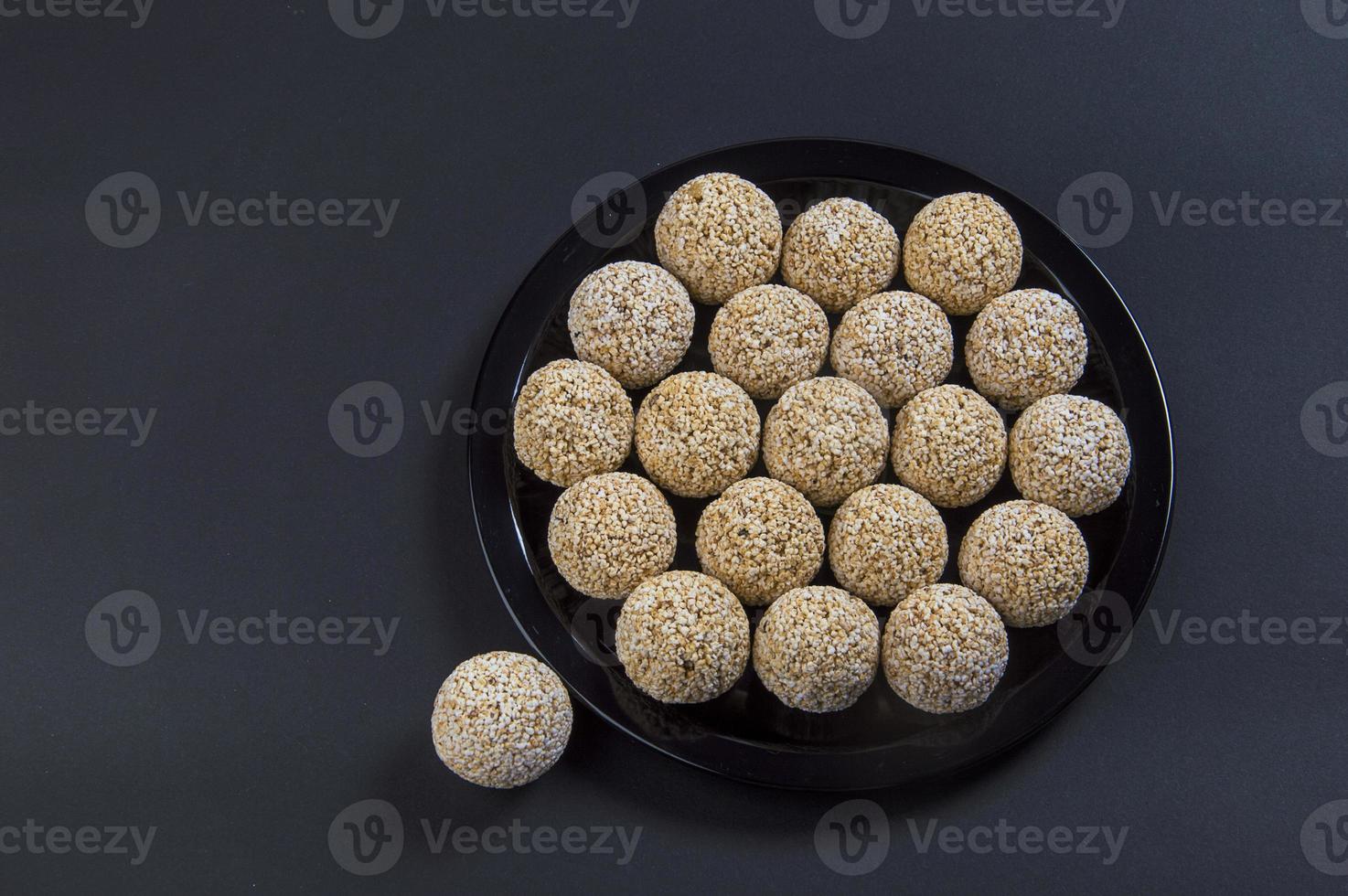 Amaranth ladoo oder rajgira laddu oder cholai ke laddo in schwarzer Platte auf schwarzem Hintergrund. foto