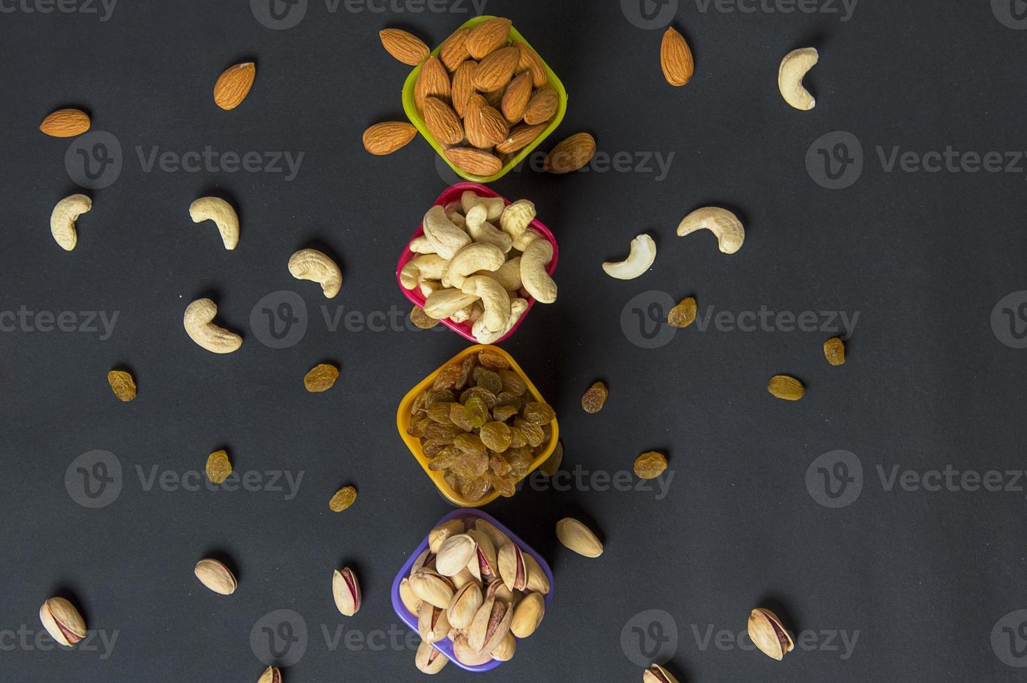 gesunde Mischung aus Trockenfrüchten und Nüssen auf dunklem Hintergrund. Mandeln, Pistazien, Cashewkerne, Rosinen foto