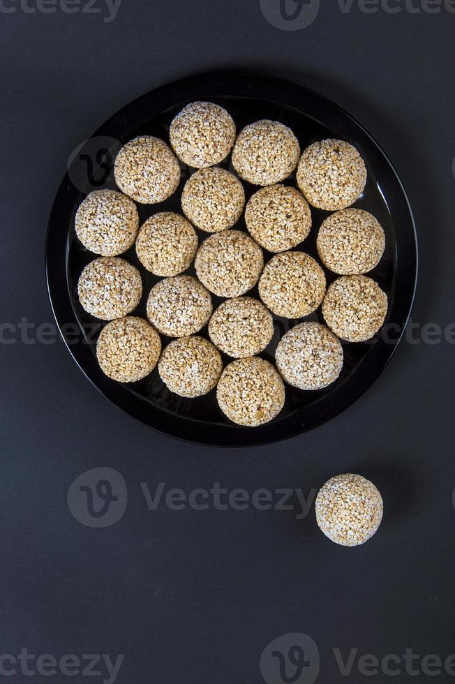 Amaranth ladoo oder rajgira laddu oder cholai ke laddo in schwarzer Platte auf schwarzem Hintergrund. foto