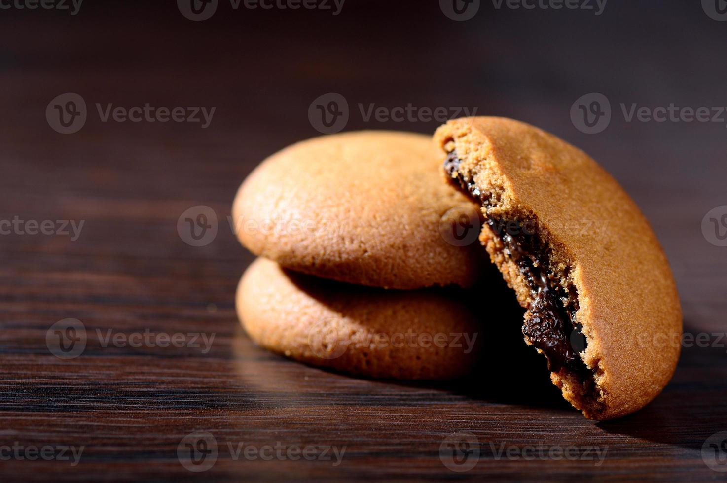 Kekse gefüllt mit Schokoladencreme. Schokoladencreme-Kekse. braune Schokoladenkekse mit Sahnefüllung auf schwarzem Hintergrund. foto