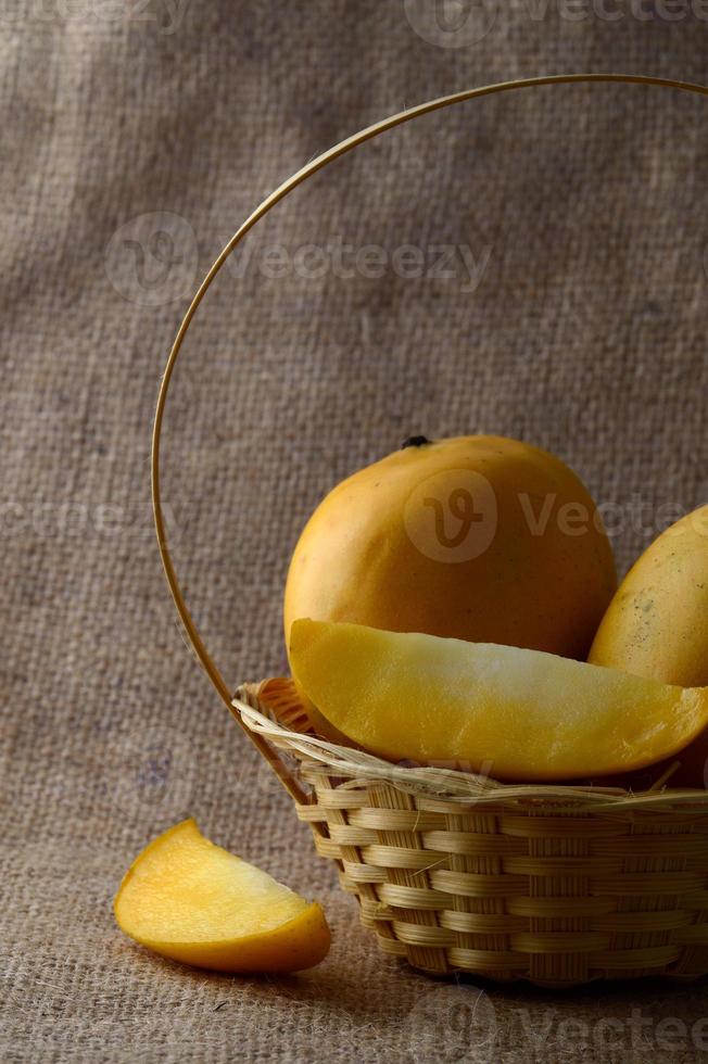 Mangofrucht im Korb auf Sackleinenhintergrund foto