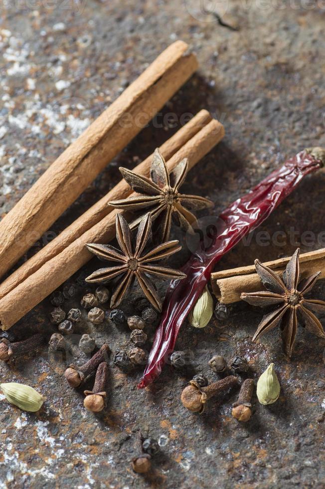 Gewürze und Kräuter. Lebensmittel und Küchenzutaten. Zimtstangen, Anissterne, schwarze Pfefferkörner, Chili, Kardamom und Nelken auf strukturiertem Hintergrund foto