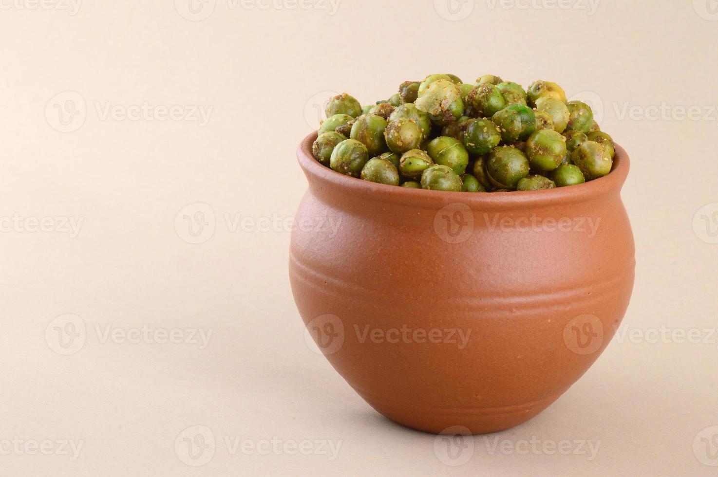 gewürzte gebratene grüne Erbsen, Chatpata Matar indischer Snack. getrocknete gesalzene grüne Erbsen im Tontopf. foto