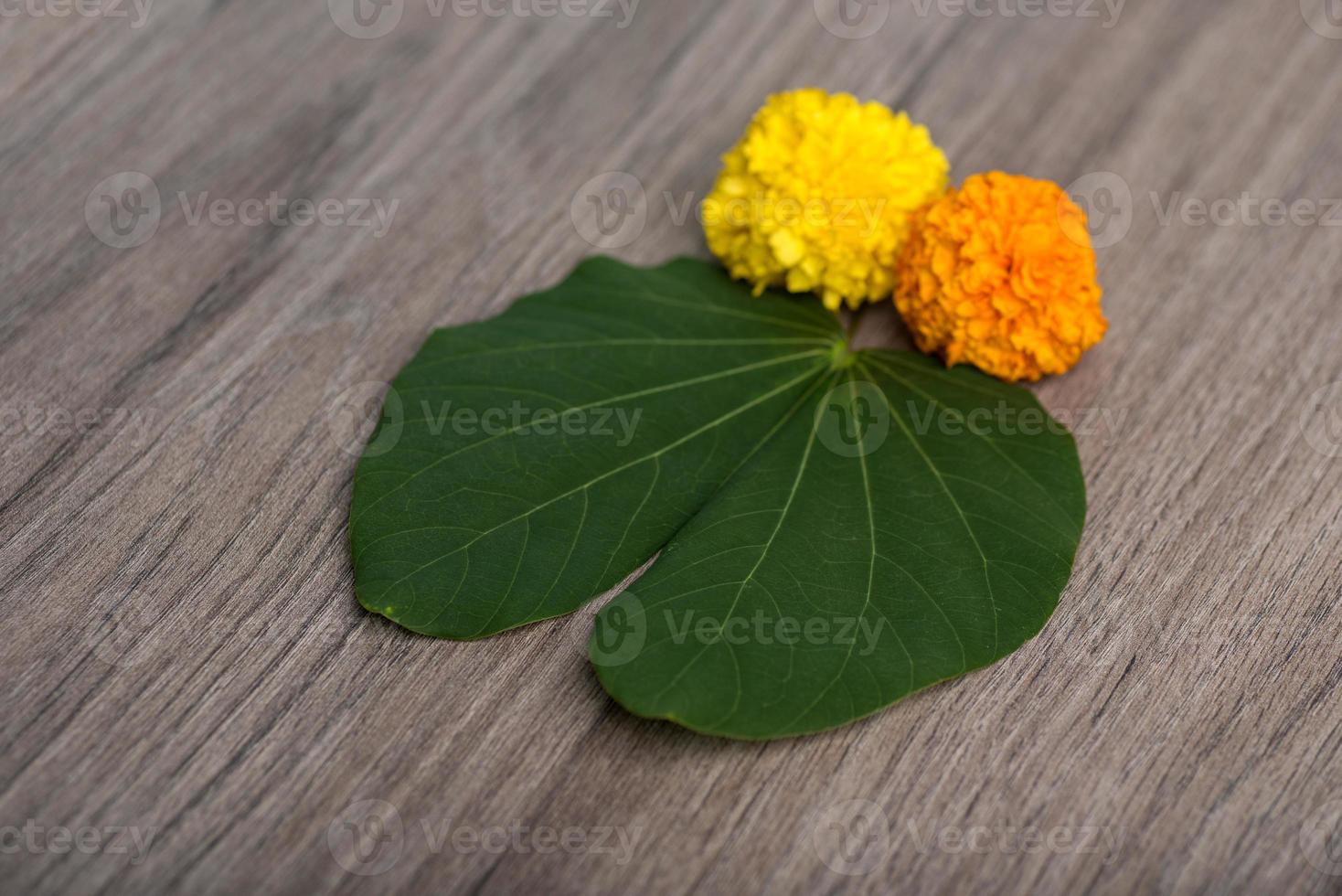 indisches Festival Dussehra, das goldene Blattbauhinia racemosa und Ringelblumen auf einem hölzernen Hintergrund zeigt. foto