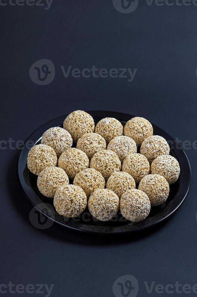 Amaranth ladoo oder rajgira laddu oder cholai ke laddo in schwarzer Platte auf schwarzem Hintergrund. foto