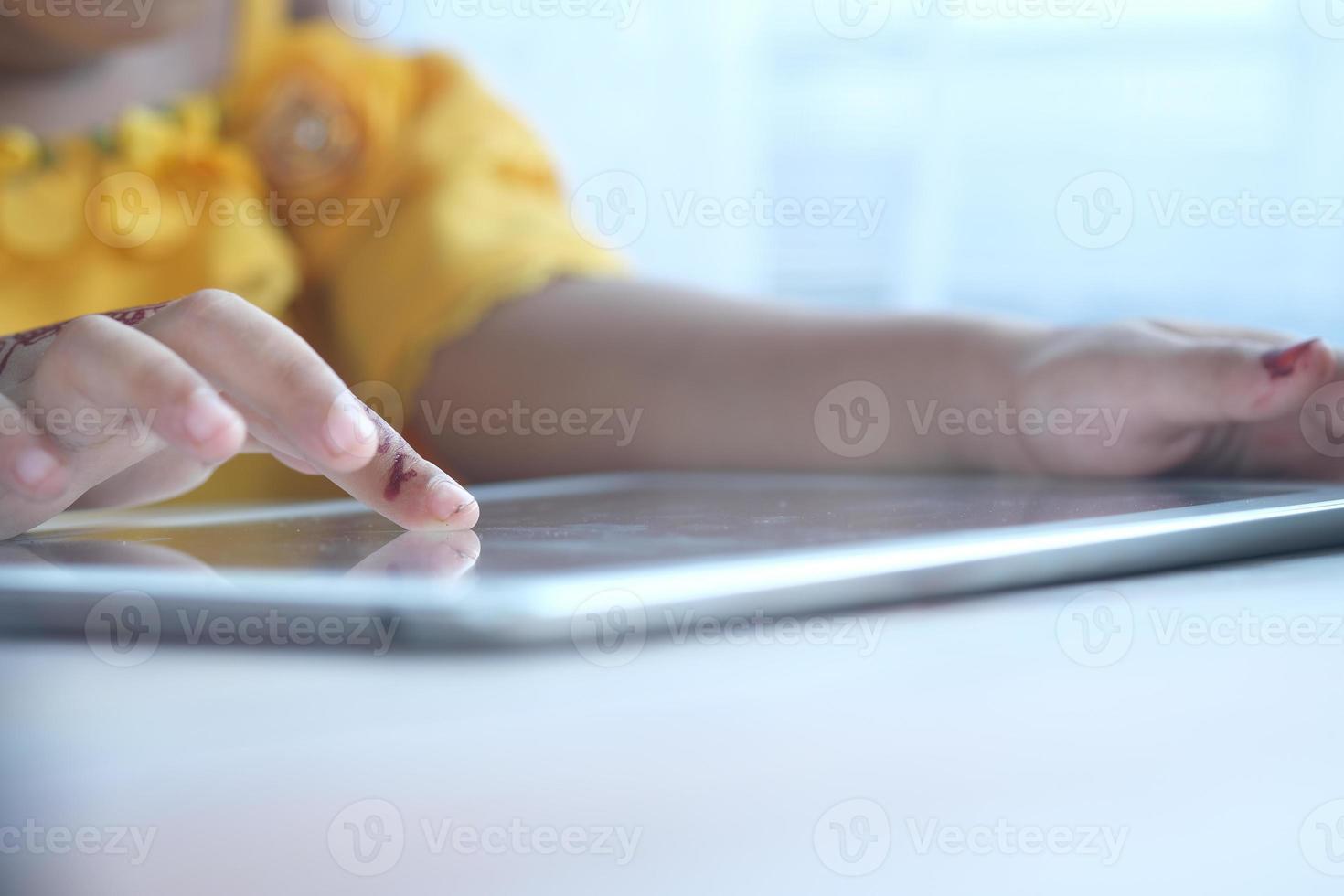 Kinderhand, die mit dem Finger auf dem digitalen Tablet-Bildschirm zeigt. foto