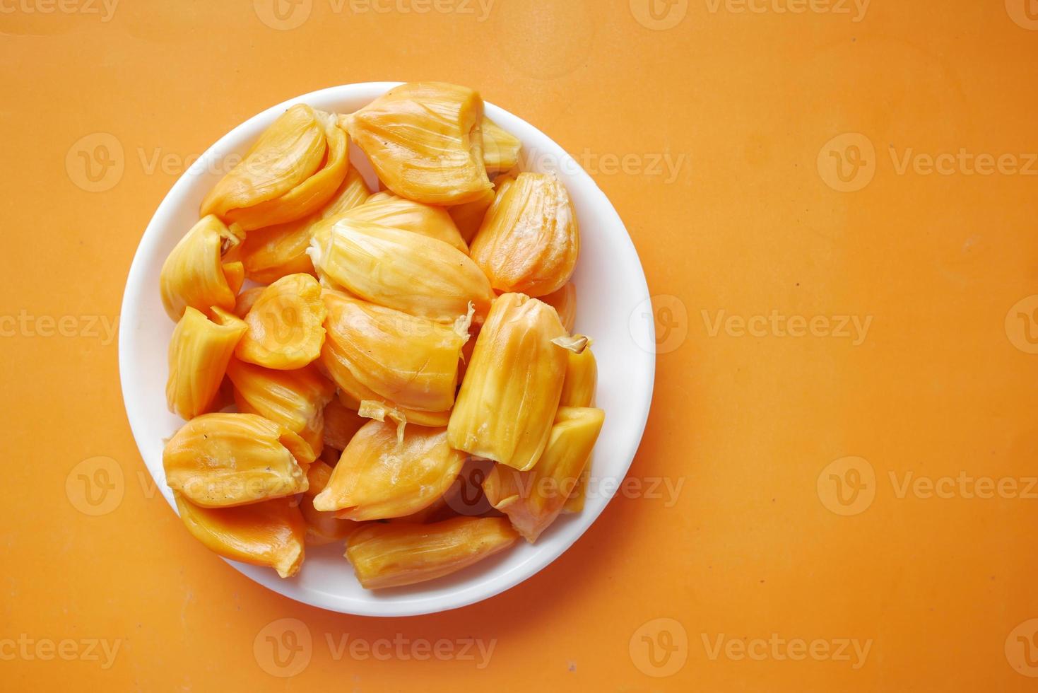 Blick von oben auf die Scheibe Jackfruits in einer Schüssel auf orangem Hintergrund. foto