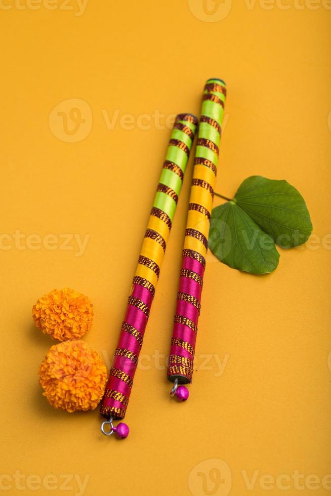 indisches festival dussehra und navratri, das goldene blattbauhinia racemosa und ringelblumen mit dandiya-sticks zeigt. foto