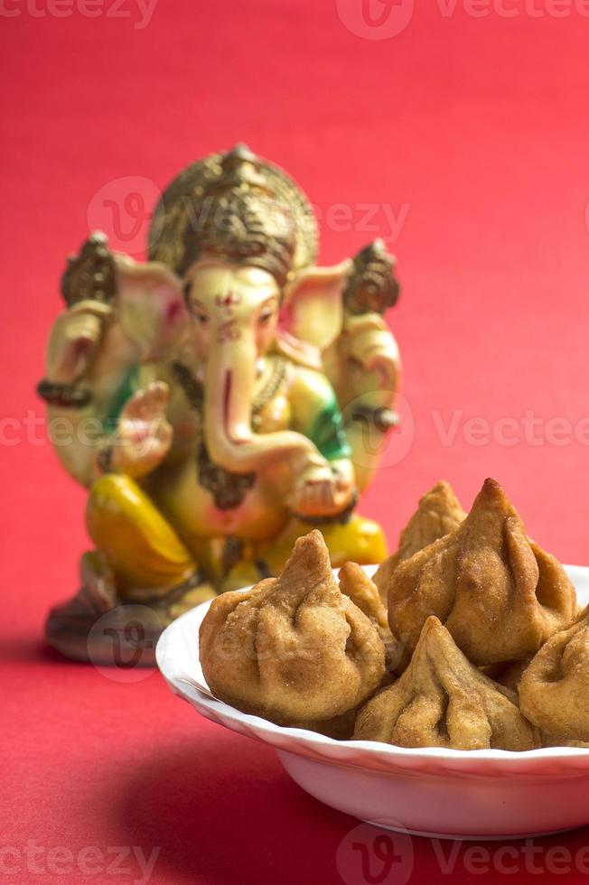 indisches Essen Modak mit Idol von Lord Ganesha, Maharashtra Süßspeise, Grußkartendesign. foto