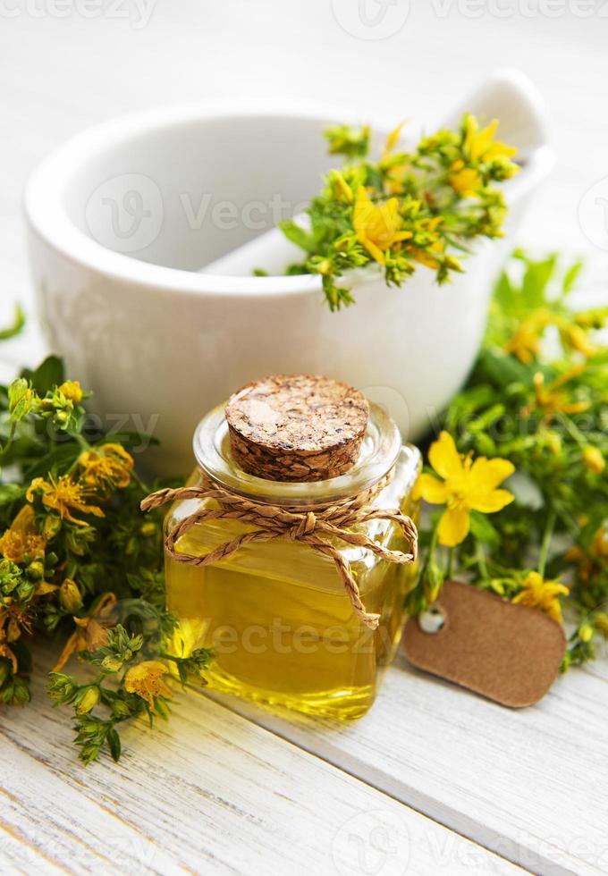 Johanniskrautöle und frische Kräuter im Mörser foto