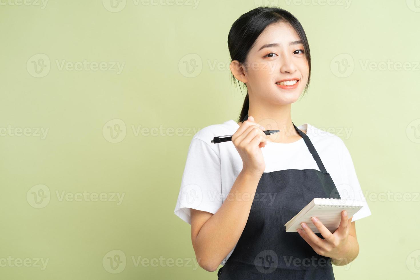 asiatische Kellnerin, die eine Notiz in der Hand hält foto