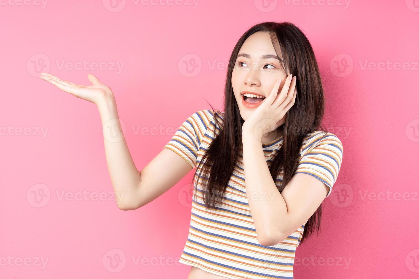 junge asiatische Frau posiert auf rosa Hintergrund foto