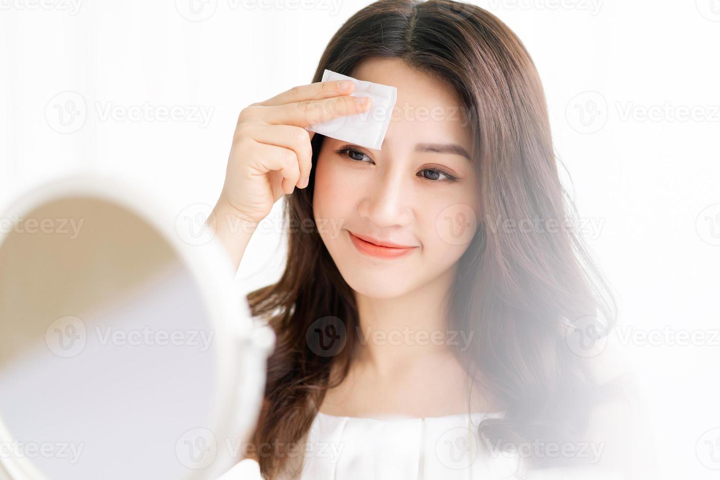 asiatische Frau sitzt Make-up vor Spiegel foto