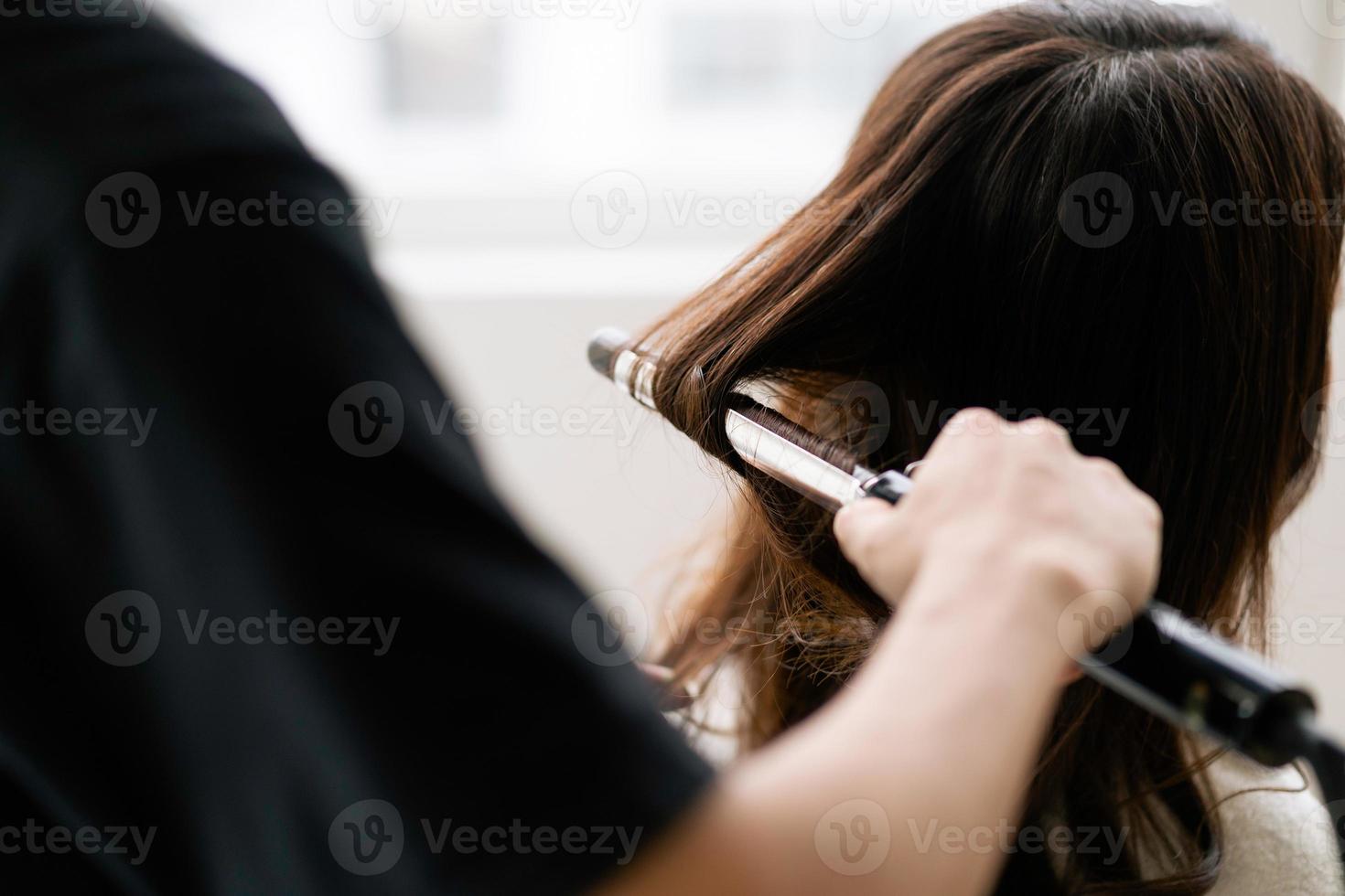 asiatische Frau mit glücklichem Ausdruck beim Friseur im Salon foto