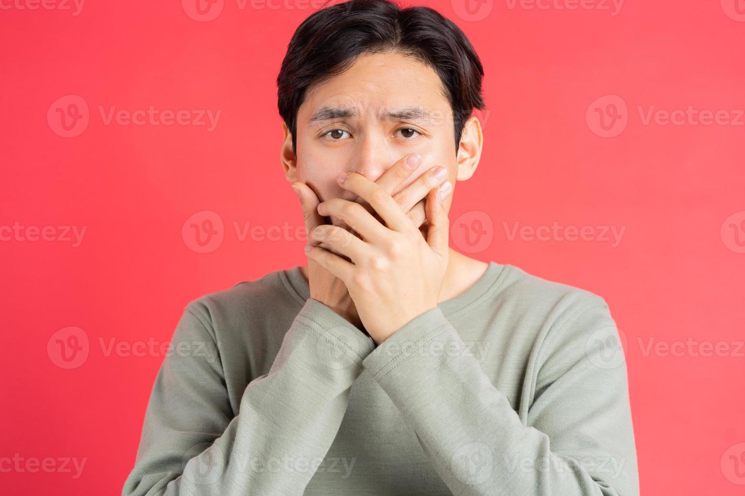 ein Foto eines gutaussehenden asiatischen Mannes, der sich den Mund zuhält, um das Geheimnis eines anderen nicht zu verpassen