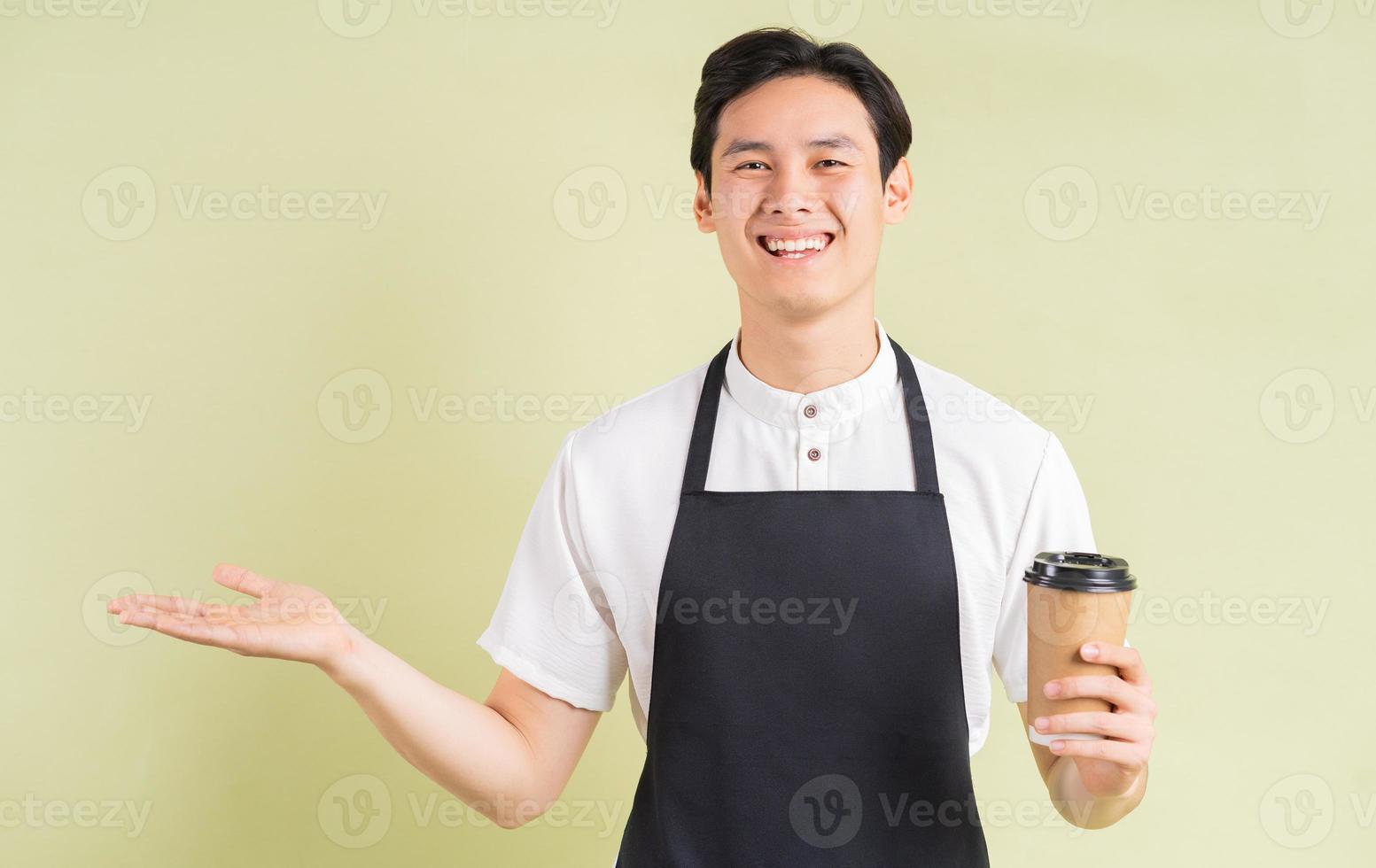 asiatischer Kellner, der Pappbecher hält und lächelt foto