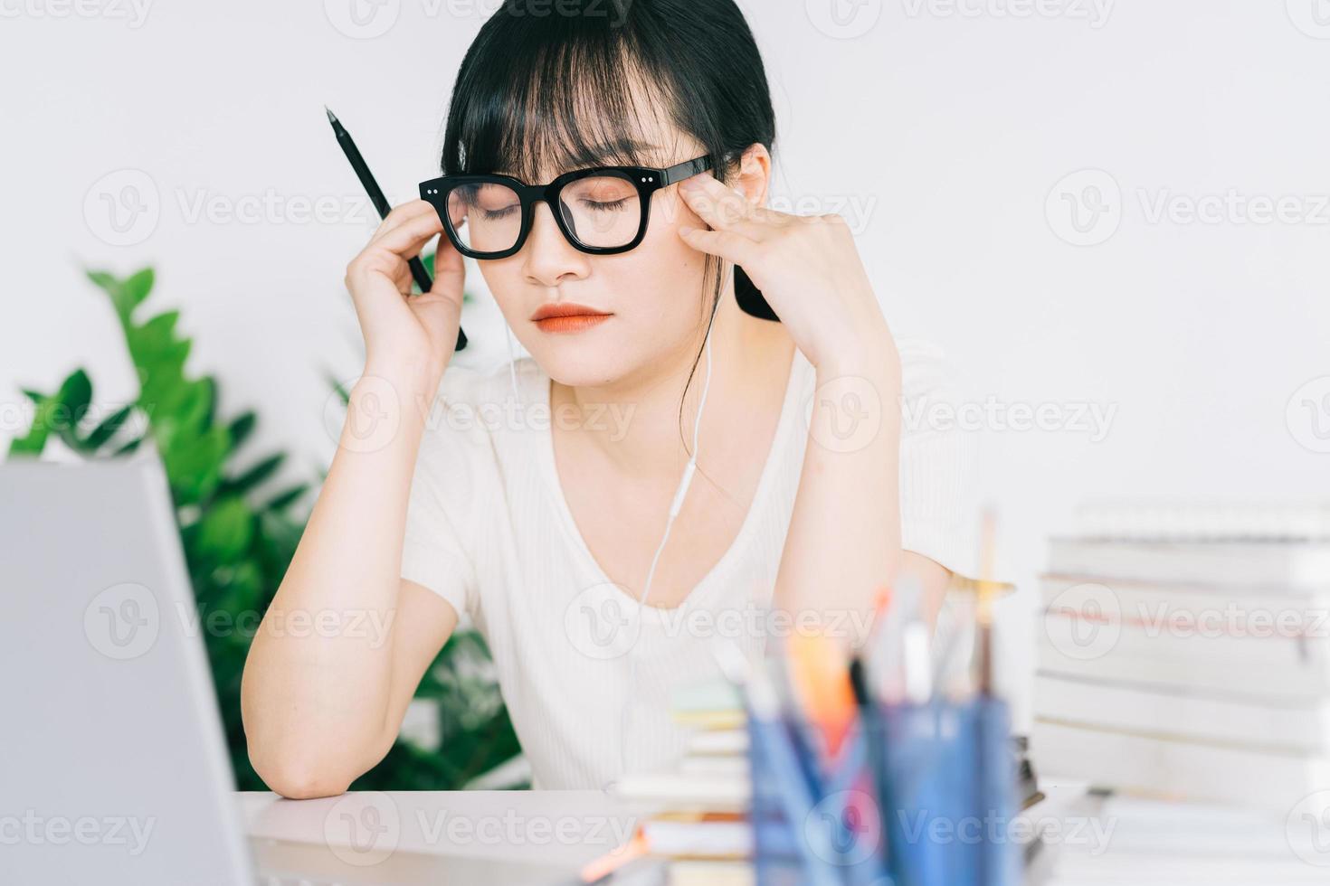 asiatische geschäftsfrau ist müde und kopfschmerzen mit viel arbeit an der frist foto