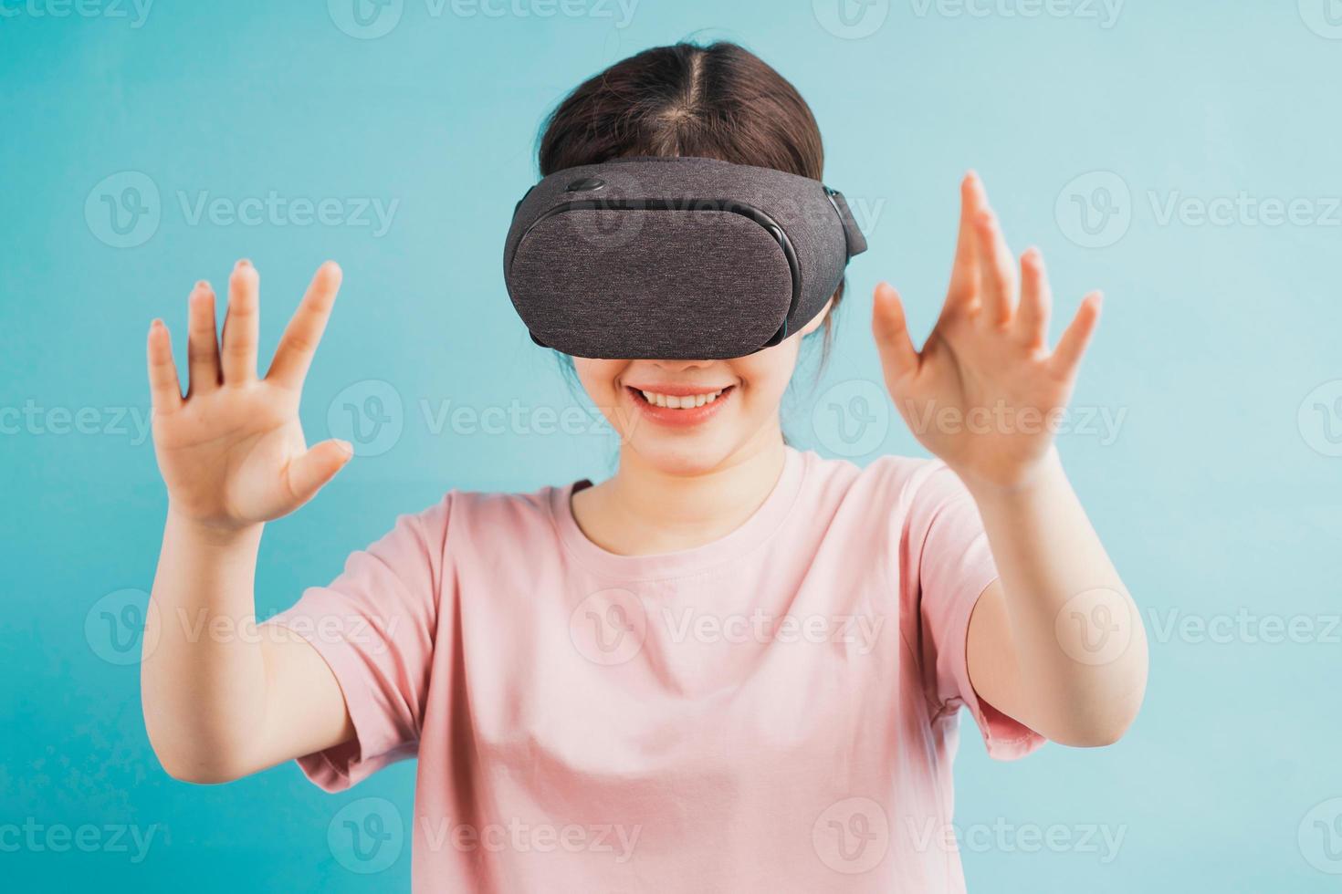Porträt eines Mädchens, das eine Virtual-Reality-Brille auf blauem Hintergrund erlebt foto