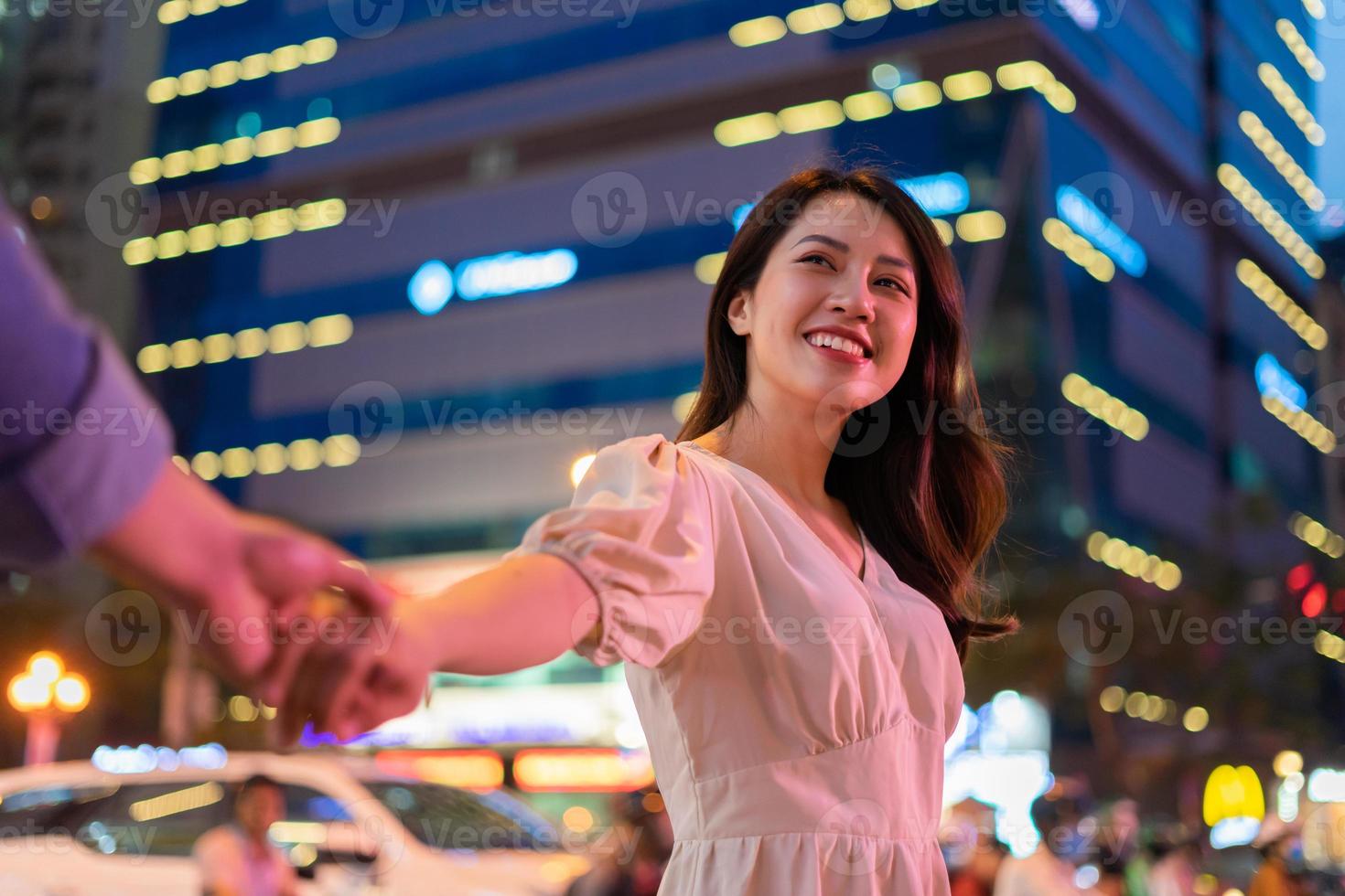 Junges asiatisches Paar, das nachts auf der Straße geht foto