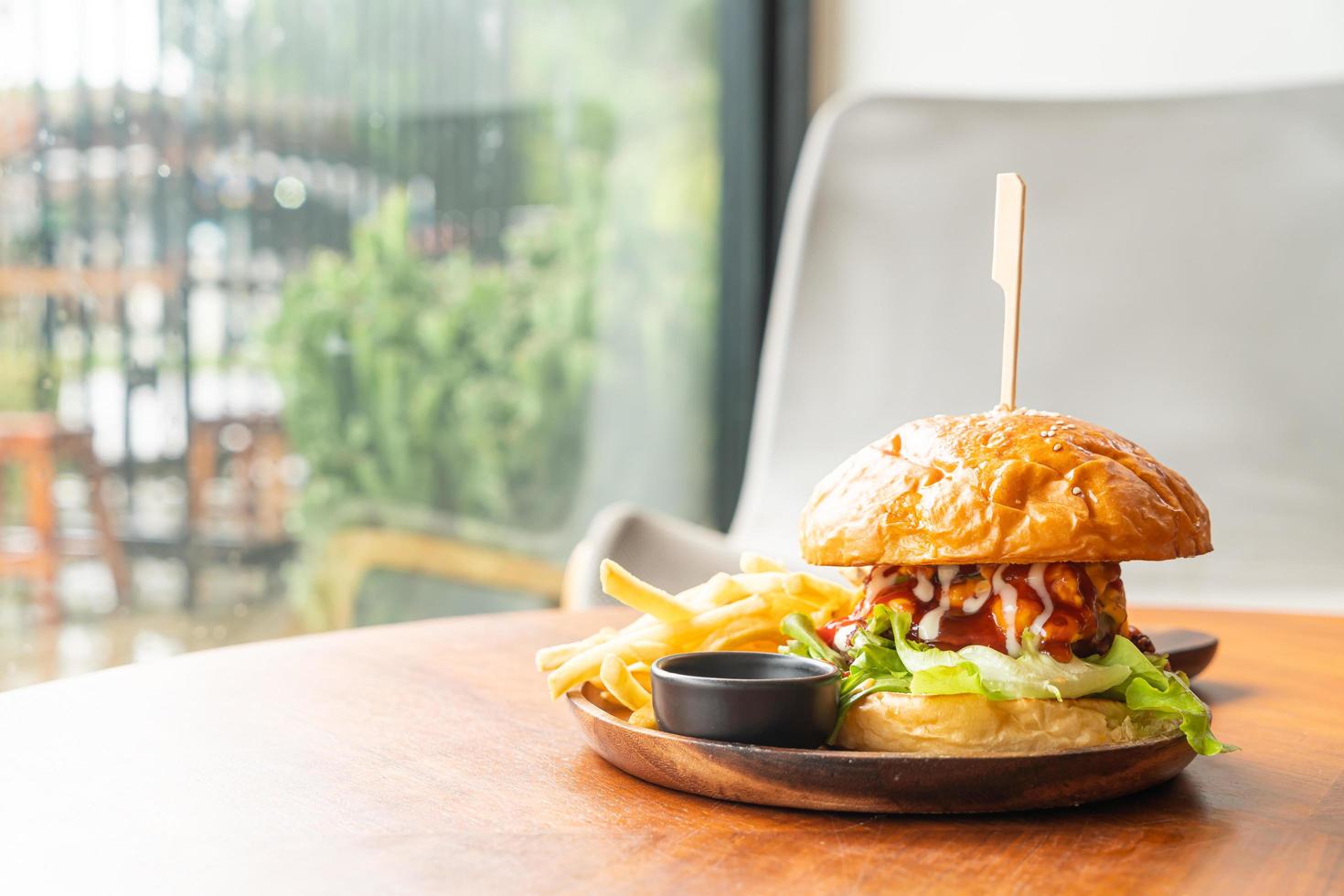 Rinderburger mit Käse und Sauce auf Holzteller foto