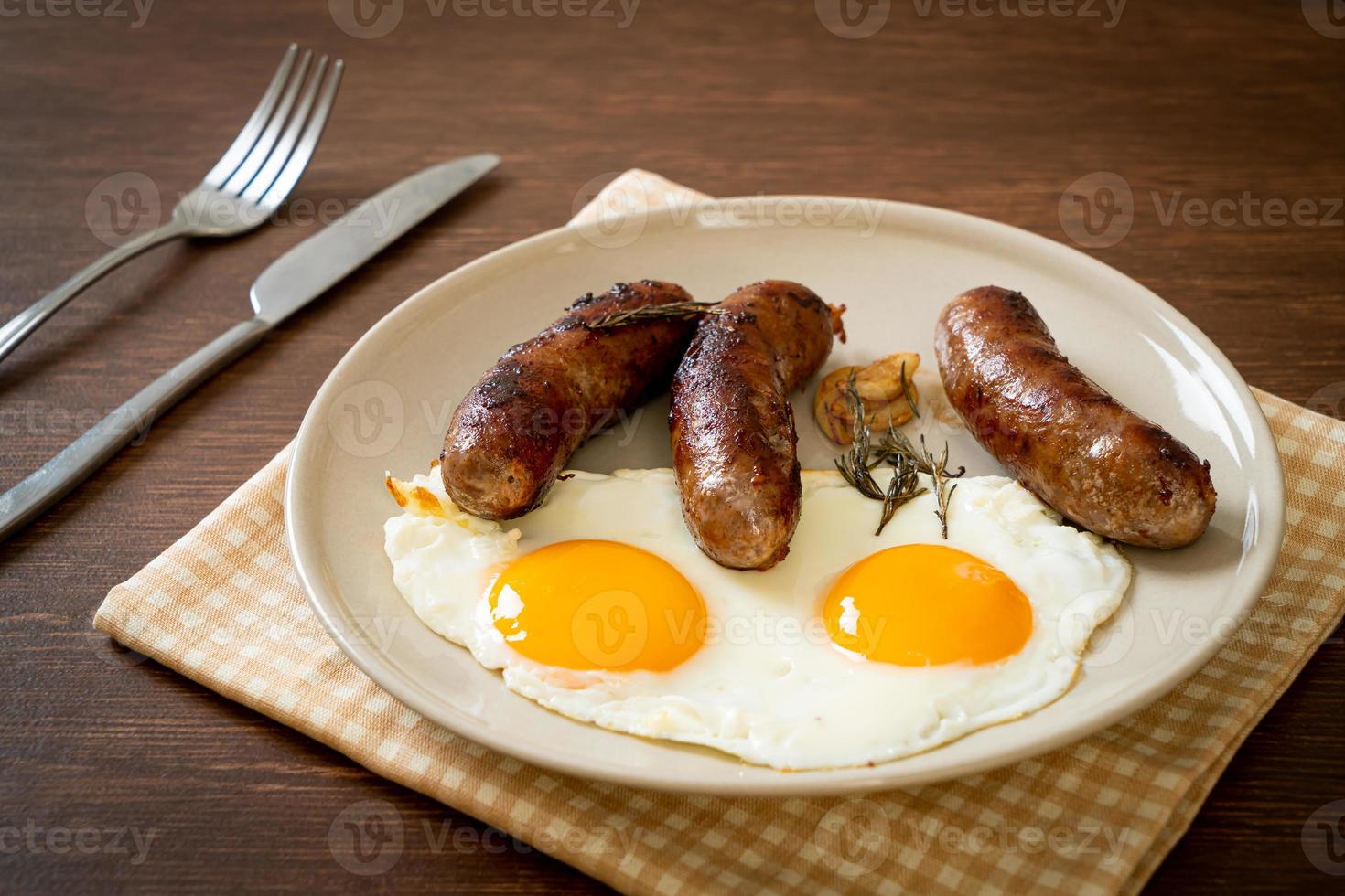 hausgemachtes doppeltes Spiegelei mit gebratener Schweinswurst - zum Frühstück foto