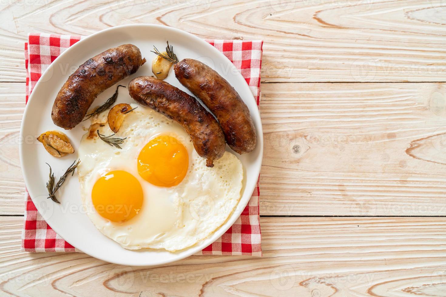 hausgemachtes doppeltes Spiegelei mit gebratener Schweinswurst - zum Frühstück foto