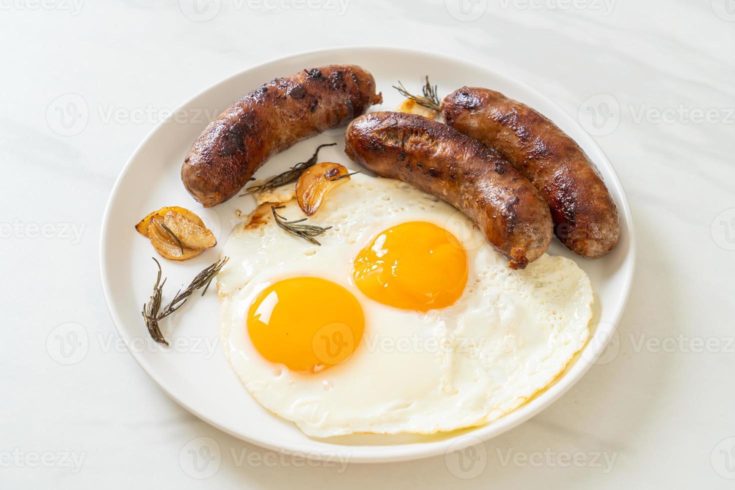 hausgemachtes doppeltes Spiegelei mit gebratener Schweinswurst - zum Frühstück foto