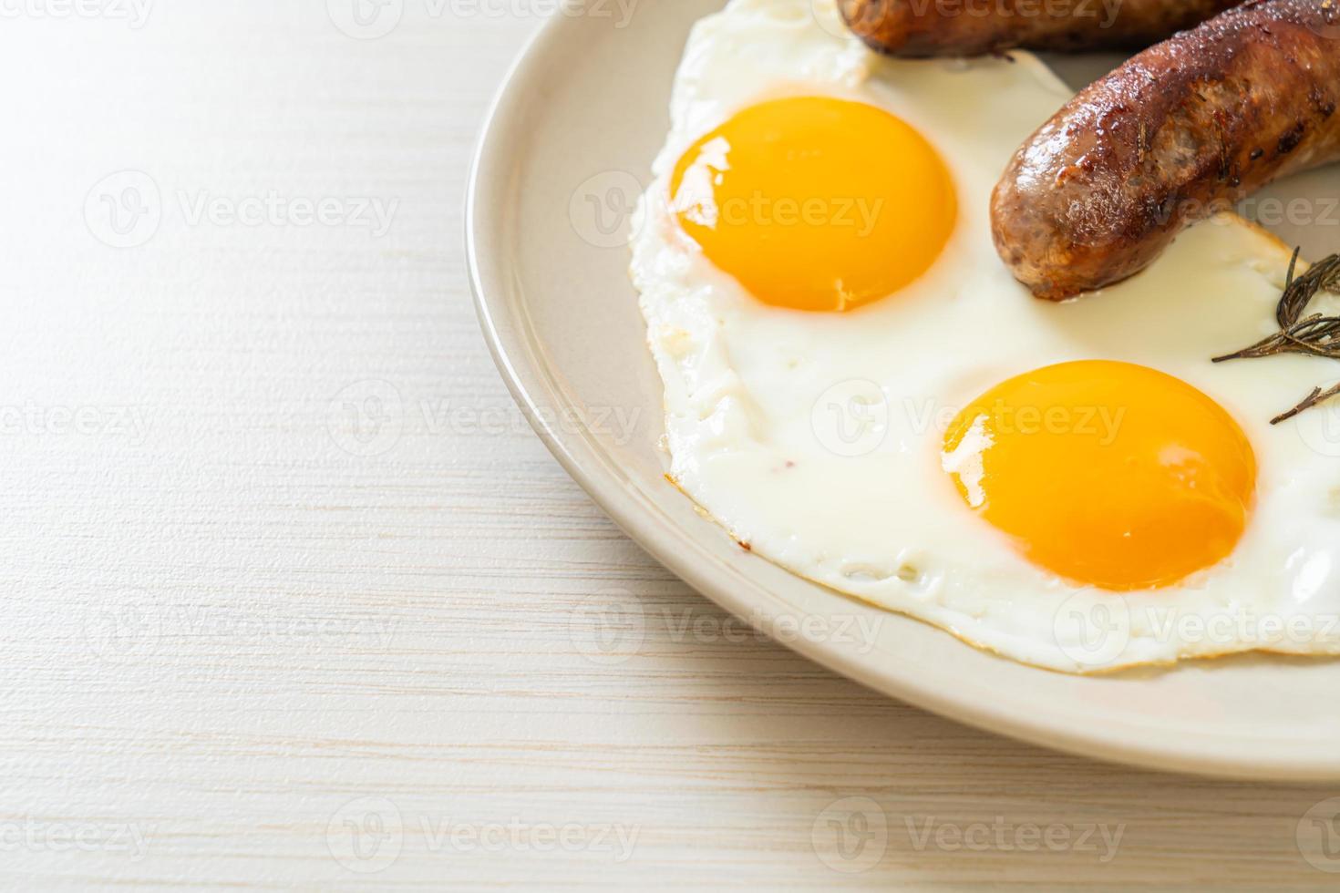 hausgemachtes doppeltes Spiegelei mit gebratener Schweinswurst - zum Frühstück foto