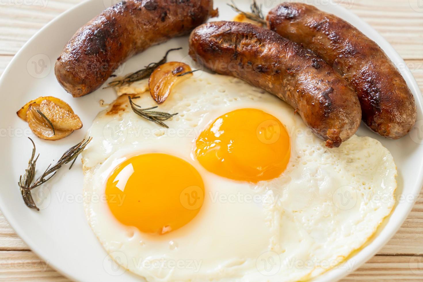 hausgemachtes doppeltes Spiegelei mit gebratener Schweinswurst - zum Frühstück foto