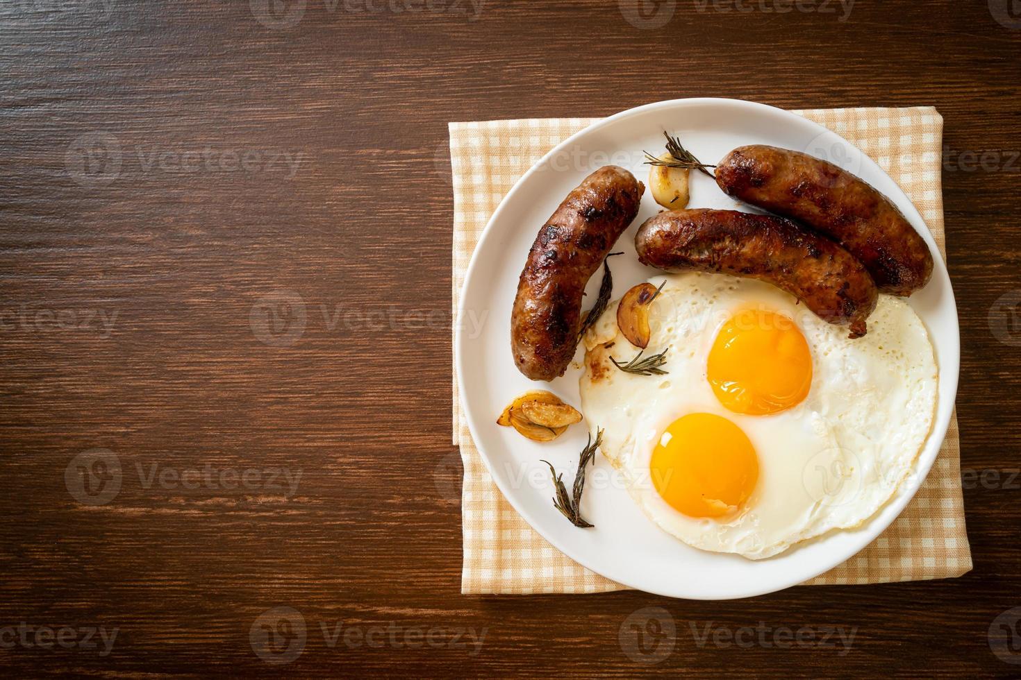 hausgemachtes doppeltes Spiegelei mit gebratener Schweinswurst - zum Frühstück foto