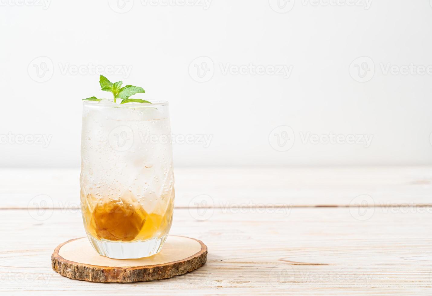 Geeister Pflaumensaft mit Soda und Pfefferminze auf dem Holztisch - Erfrischungsgetränk foto