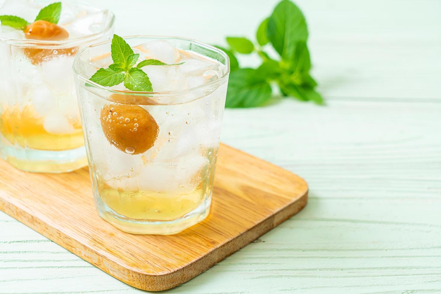 Geeister Pflaumensaft mit Soda und Pfefferminze auf dem Holztisch - Erfrischungsgetränk foto