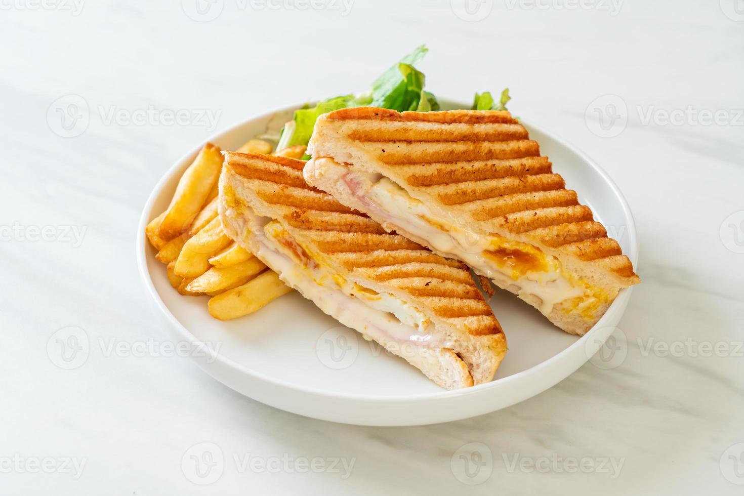 Schinken-Käse-Sandwich mit Ei und Pommes foto