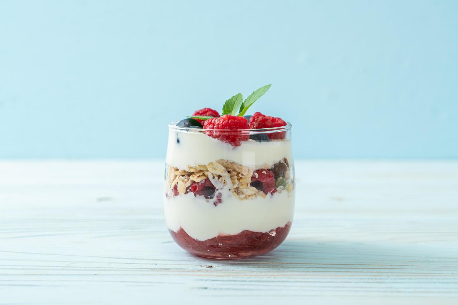 hausgemachte Himbeeren und Heidelbeeren mit Joghurt und Müsli - gesunder Ernährungsstil foto