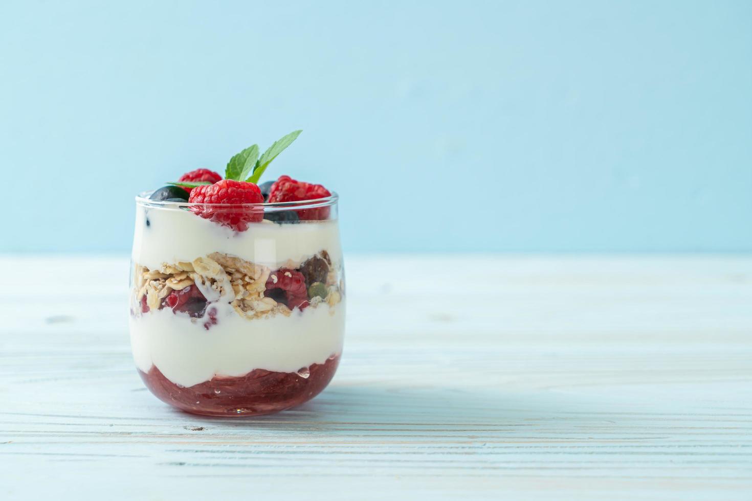 hausgemachte Himbeeren und Heidelbeeren mit Joghurt und Müsli - gesunder Ernährungsstil foto