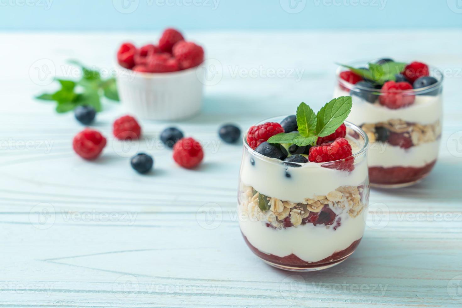 hausgemachte Himbeeren und Heidelbeeren mit Joghurt und Müsli - gesunder Ernährungsstil foto